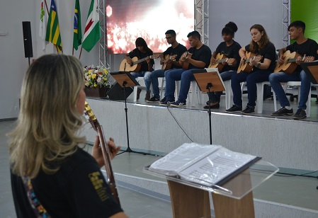 Alunos durante apresentação e acompanhados pela profa. Daniela Oliveira